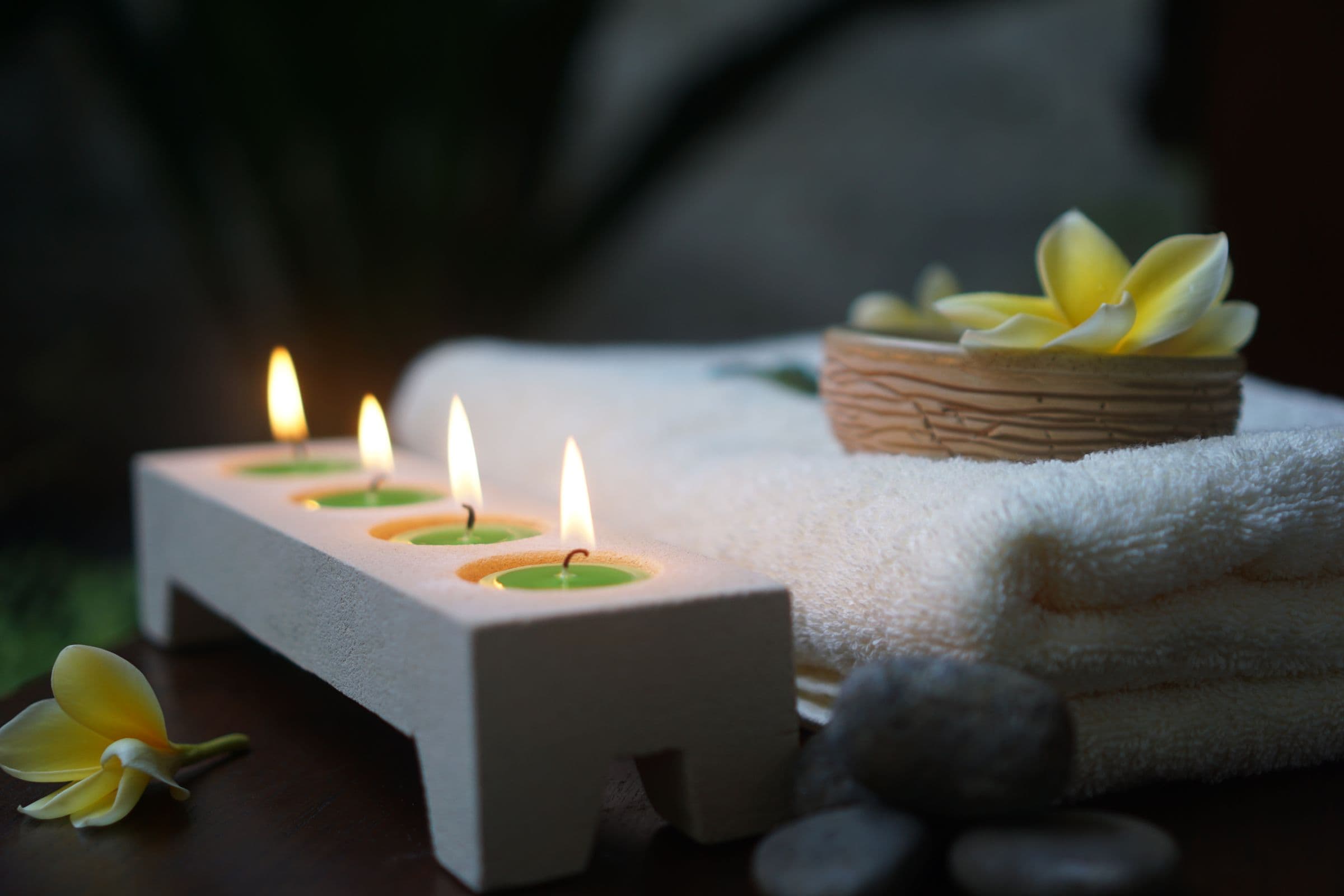 Candles, folded towels and flowers set for a member visit